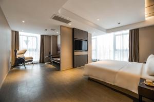 寧波的住宿－宁波外滩路劲新天地亚朵酒店，酒店客房设有一张大床和一张书桌。
