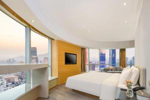 ein Schlafzimmer mit einem weißen Bett und einem großen Fenster in der Unterkunft Atour X Hotel Wuxi Sanyang Plaza Zhongshan Road in Wuxi