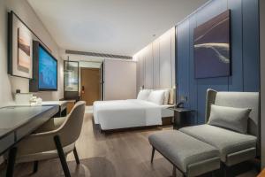 a hotel room with a bed and a desk and chairs at Atour Hotel Chengdu East Jiuyanqiao Street in Chengdu
