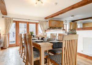 Il comprend une cuisine et une salle à manger avec une table et des chaises en bois. dans l'établissement Beacons View Farm Cottages, à Merthyr Cynog