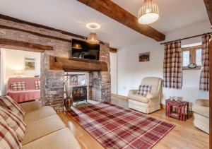 a living room with a fireplace and a couch at Beacons View Farm Cottages in Merthyr Cynog