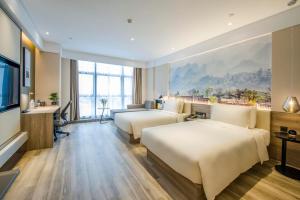 a hotel room with two beds and a flat screen tv at Atour Hotel Foshan Nanhai Qiandeng Lake Guicheng in Nanhai