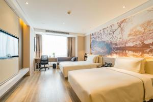 una camera d'albergo con due letti e una scrivania di Atour Hotel Changjiang North Road Wuxi a Wuxi