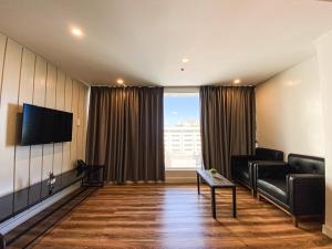 a living room with a couch and a tv at Wesfame Suites in Manila
