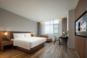 a hotel room with a bed and a flat screen tv at Atour X Hotel Hangzhou Binjiang Torch Avenue in Hangzhou