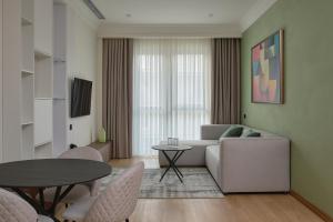 een woonkamer met een bank en een tafel bij STYLO Residences & Suites in Tasjkent