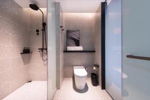 a bathroom with a white toilet and a shower at Atour S Hotel Ningbo Binjiang Olympic Sports Center in Ningbo