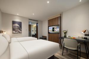 a hotel room with a white bed and a desk at Atour X Hotel Hangzhou Binjiang Torch Avenue in Hangzhou