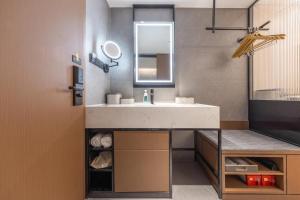 a bathroom with a sink and a mirror at Atour X Hotel Shantou Vientiane City Convention and Exhibition Center in Shantou