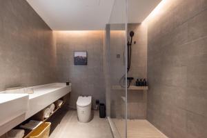 La salle de bains est pourvue d'une douche, de toilettes et d'un lavabo. dans l'établissement Atour Hotel Guangzhou Baiyun Jiahe Hebian, à Canton