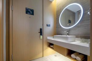 uma casa de banho com um lavatório e um espelho em Atour Hotel Ningbo Zhenhai New City em Ningbo