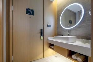 a bathroom with a sink and a mirror at Atour Hotel Ningbo Zhenhai New City in Ningbo