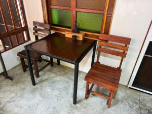a wooden table and two chairs and a table and a table and two chairs at Pagi Pagi villas in Ao Nang Beach