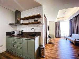 uma cozinha com um balcão e uma sala de estar em Wesfame Suites em Manila