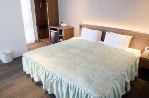 a hotel room with a bed with a blue comforter at Ginza International Hotel in Tokyo
