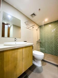 y baño con lavabo, aseo y ducha. en Wesfame Suites en Manila