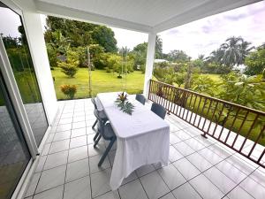 un tavolo bianco e sedie sul balcone di ATITAUTU Guest House a Tautira