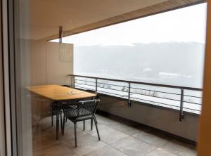 einen Tisch und Stühle in einem Zimmer mit einem großen Fenster in der Unterkunft Bella Vista Seeblick in Annenheim