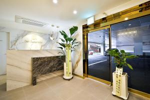 a lobby with two vases with plants in it at Denbasta Hotel Daeyeon in Busan