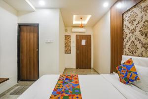 una camera con letto e porta in legno di FabExpress Jai Manglam Service Apartment a Nagpur