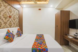 una camera con un letto bianco e una TV di FabExpress Jai Manglam Service Apartment a Nagpur