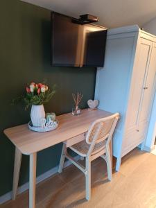 a wooden table with a chair and a microwave at My Little Village in Poiana Mărului