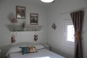 a white bedroom with a bed and a window at Clauhomes Oh La Lá in Tarragona