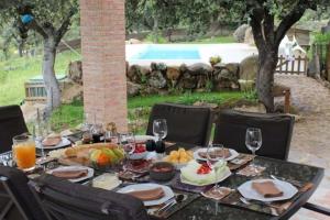 een tafel voor een maaltijd met een zwembad op de achtergrond bij Finca Marowa in Salvatierra de Santiago