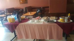 a table with a pink table cloth with food on it at Jamia Central Hotel in Nairobi