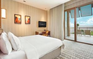 Resorts World Sentosa - Equarius Hotel في سنغافورة: غرفه فندقيه بسرير وشرفه