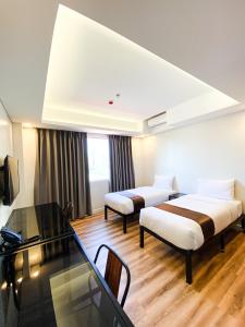 Wesfame Suites في مانيلا: غرفة فندقية بسريرين وطاولة