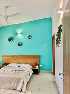 1 dormitorio con una pared azul y 1 cama en A Home Away from Home., en Fumba