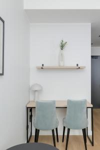 a table with two chairs in a room with white walls at Modern Studios in the Centre of Poznań by Noclegi Renters in Poznań