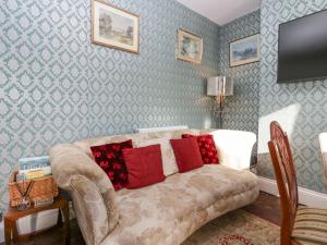 sala de estar con sofá y almohadas rojas en Vale View en Egremont