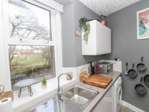 una pequeña cocina con fregadero y ventana en Vale View en Egremont