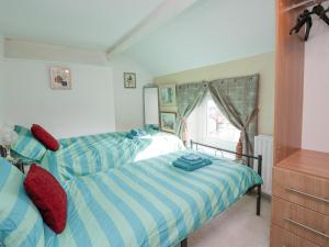 a bedroom with two beds and a window at Vale View in Egremont