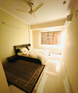 a small bedroom with a bed and a painting on the wall at Zephyr Lodge in Islamabad