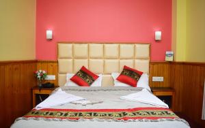 a bedroom with a large bed with red walls at Rufina Lachung Heritage in Lachung