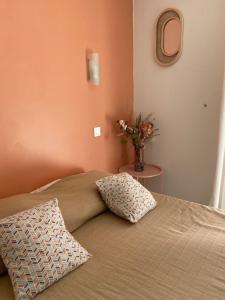 - un lit avec un oreiller et un vase de fleurs dans l'établissement Cascade, à Argelès-sur-Mer