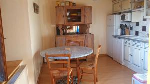 La cuisine est équipée d'une table, de chaises et d'un réfrigérateur. dans l'établissement Gîte à la campagne 3 * proche A75 en Margeride., à La Roche