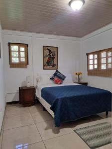 a bedroom with a large bed with a blue blanket at Jicote finca de ecoturismo in Cartago