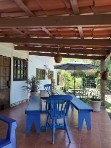 eine Terrasse mit einem blauen Tisch, Stühlen und einem Sonnenschirm in der Unterkunft Jicote finca de ecoturismo in Cartago