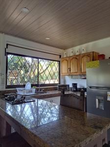 a kitchen with a large counter and a refrigerator at Jicote finca de ecoturismo in Cartago