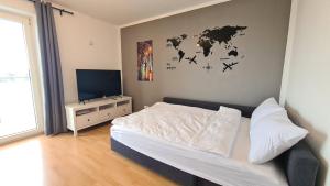 1 dormitorio con 1 cama y un mapa mundial en la pared en Cozy 2-Room Flat, for Vacation & Fair (Messe Düsseldorf), en Ratingen