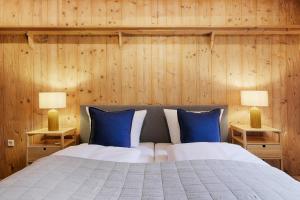 a bedroom with a bed with blue pillows and two lamps at Fewos am Main mit Dachterrasse & Fahrradgarage - by homekeepers in Ochsenfurt