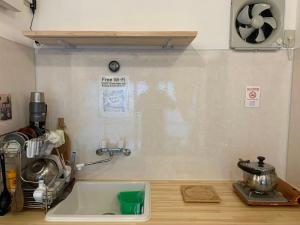 a kitchen with a sink and a counter top with a counter top at Kanchantei The Tiny House in Minamicho