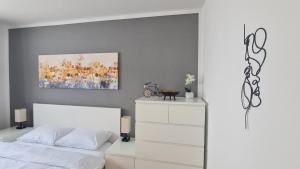 Un dormitorio con una cama blanca y una pintura en la pared en Cozy 2-Room Flat, for Vacation & Fair (Messe Düsseldorf), en Ratingen