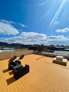a rooftop deck with chairs and a blue sky at Sarusawaike Yoshidaya in Nara
