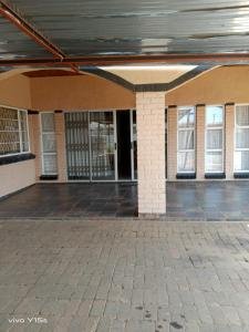 an empty building with doors and windows on it at Bullez guest house in Mahikeng