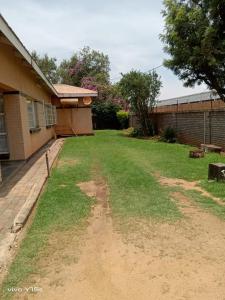 un patio con un camino de tierra delante de una casa en Rz guest house, en Mahikeng